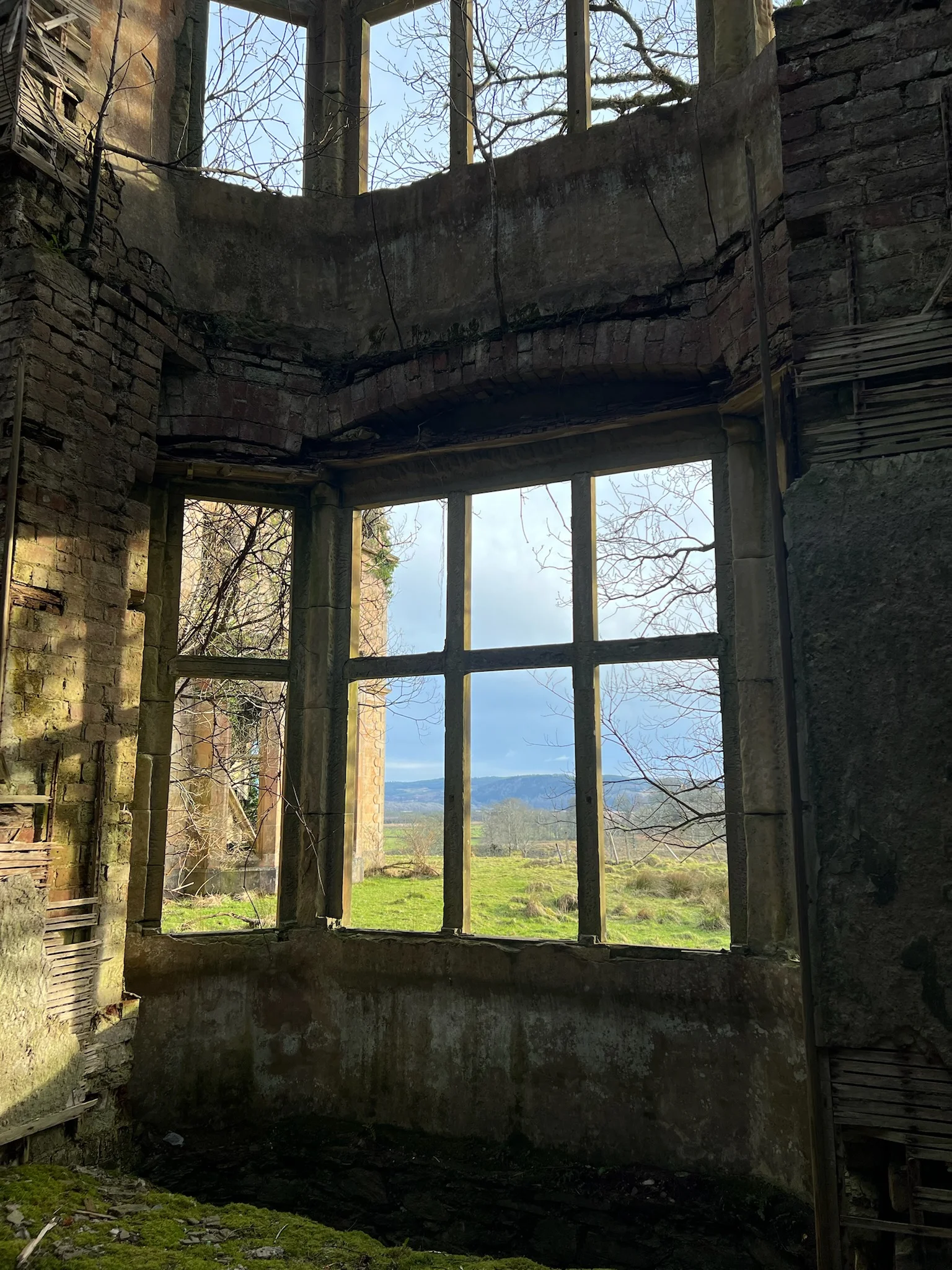 View out of a broken window at Poltalloch House